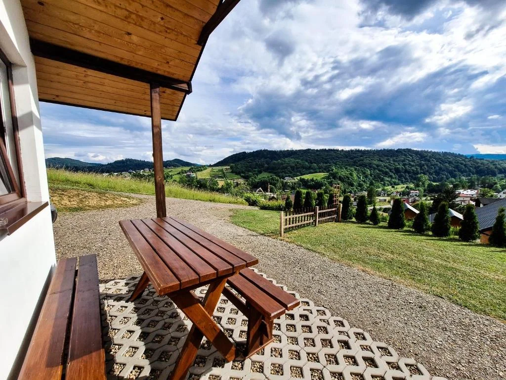 Taras z drewnianym stołem i przepiękną panoramą Bieszczad